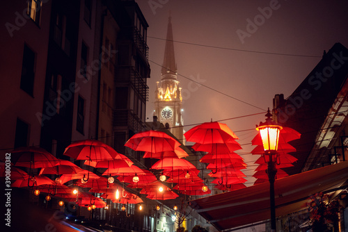 Schilderij op canvas Pedestrian street in the center of Novi Sad decorated with red umbrellas overloo