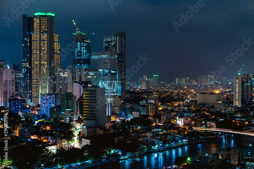 Makati, Metro Manila, Philippines - Nov 2020: Night view of North Makati and Century City skyline as seen from the opposite side of the Pasig River. Makati City Hall in the right of photo photo