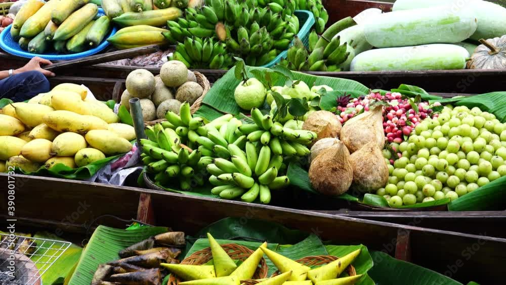 Various tropical fruit in boats selling at floating market in Samut Songkhram province, Thailand.