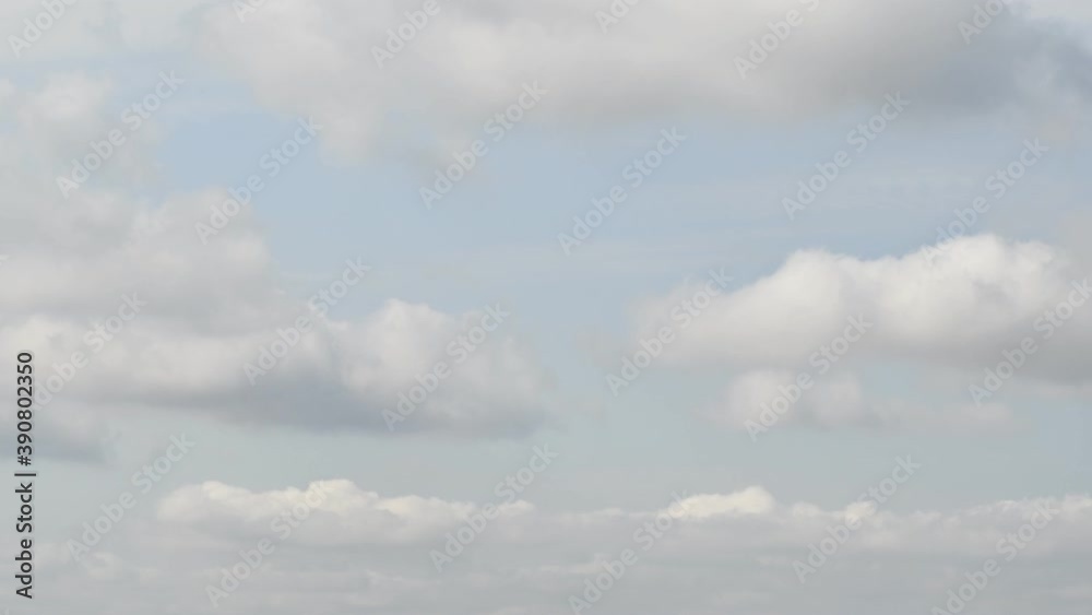 Time lapse of blue sky with white fluffy clouds floating in wind. Windy cloudscape with grey smoke formation Time lapse of blue sky with white fluffy clouds floating in wind. Windy cloudscape with grey smoke formation