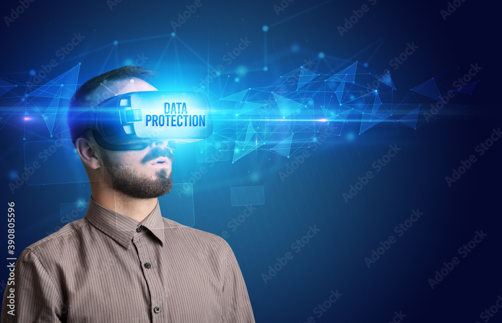 Businessman looking through Virtual Reality glasses with DATA PROTECTION inscription, cyber security concept Businessman looking through Virtual Reality glasses with DATA PROTECTION inscription, cyber security concept