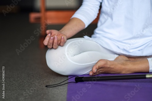 A woman in white clothes is doing kundalini yoga. Gong meditation. Asana for concentration. Healthy lifestyle, sports and stretching. Pody part photo