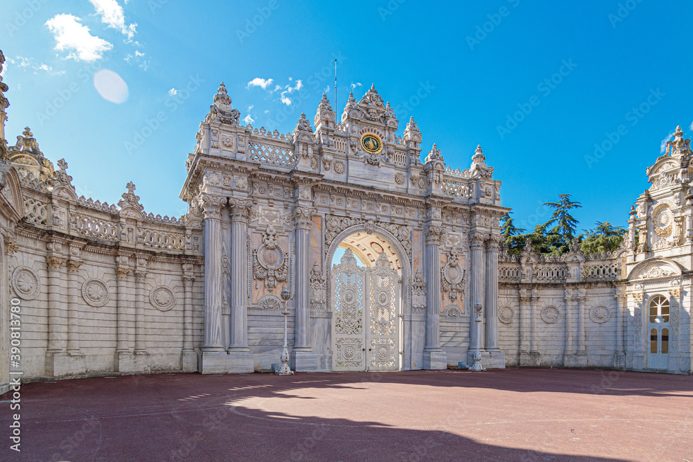 The luxurious North Gate of Dolmabahce Palace. Beautiful white stone gates with columns are decorated with carvings, turrets and gilding