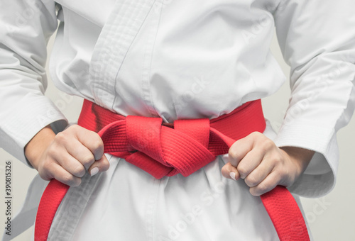 hands grabbing red karate belt