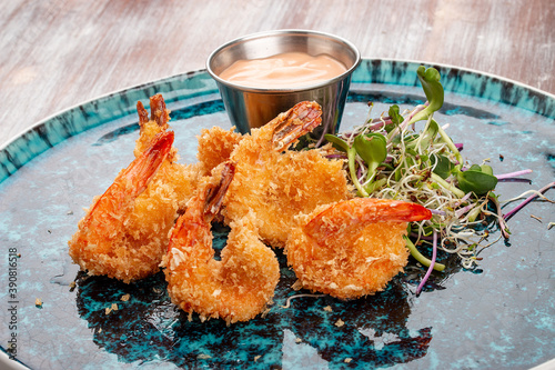Fried tiger prawns with sauce on a decorative plate