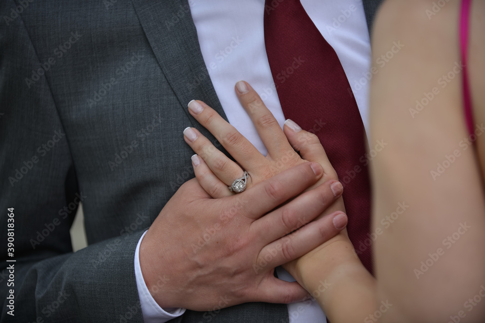 Couple's hands with and engagement ring on a man's chest