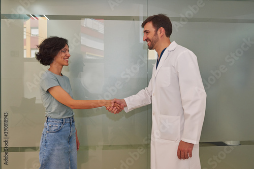 The doctor shakes hands with his patient in the clinic.