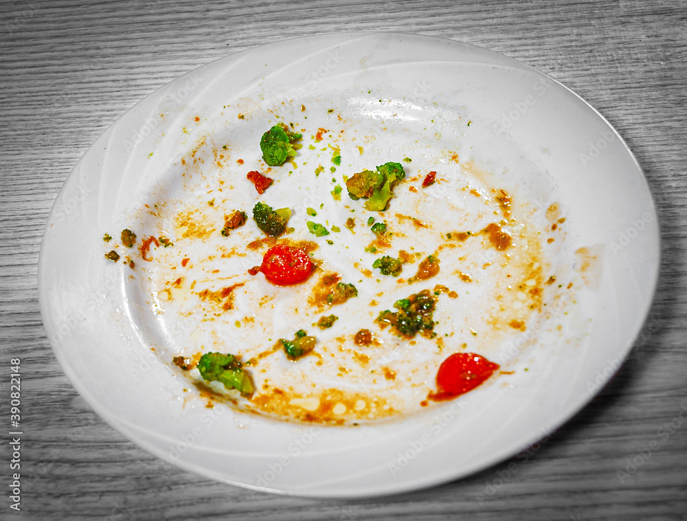 dirty plate with leftover food on the table dirty plate with leftover food on the table