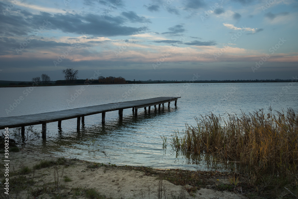 Wooden pier and reeds on the shore of the lake