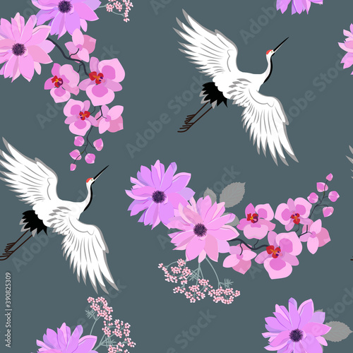 Seamless vector illustration with birds cranes, dahlia and orchid on dark gray background .