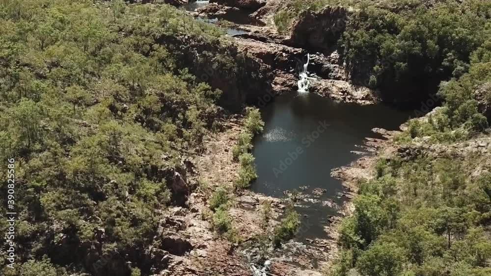River stream flowing over cliff face into large water hole River stream flowing over cliff face into large water hole