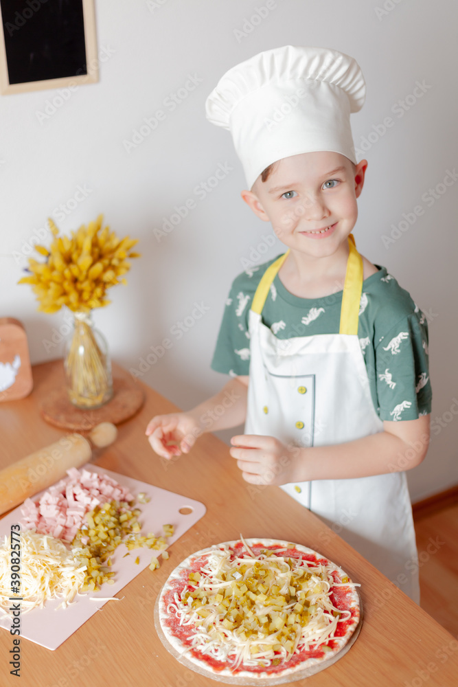 child cook preparing pizza in his kitchen