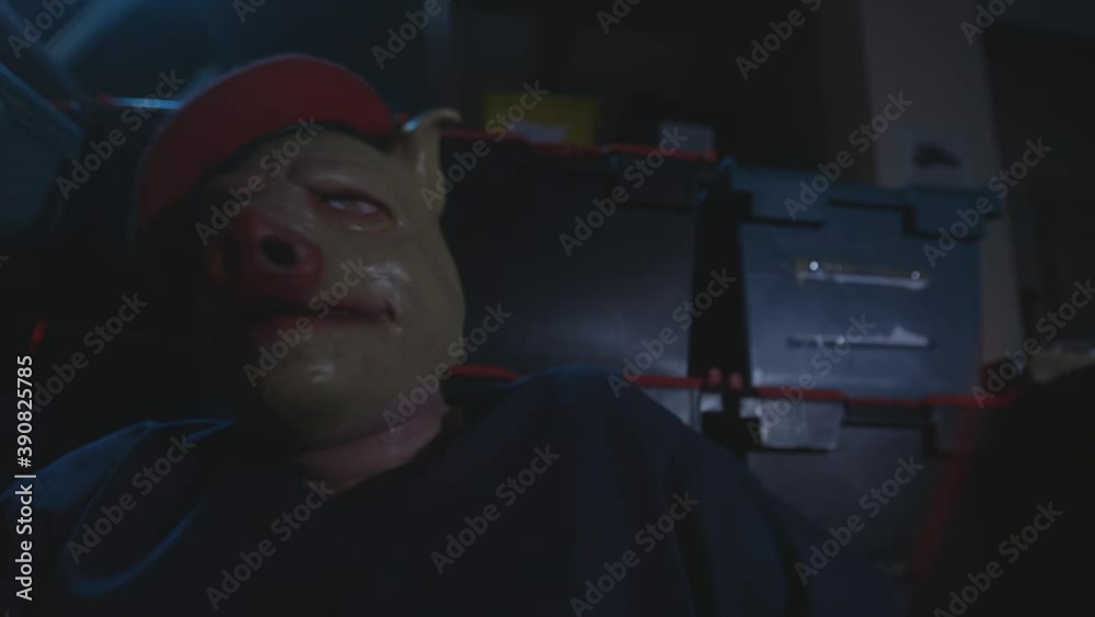 Man in pig mask suddenly hyperventilates and struggles while tied to a