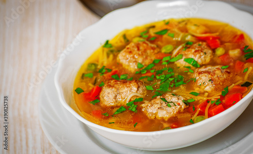 Soup with meatballs, noodle and vegetables in bowl