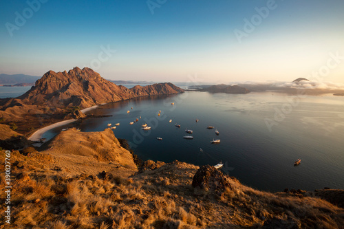Sunrise over mountains and sea with sailing ships at Rinca (Komodo National Park) 