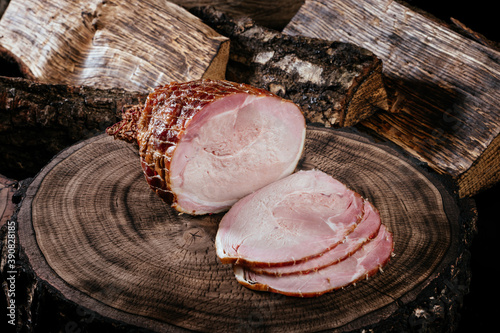 Smoked pork bacon half a piece on a wooden board, sliced ​​pork. Top view. Close up.