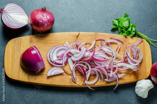 Red onion sliced. The process of cooking on a yellow cutting Board. Flat top view