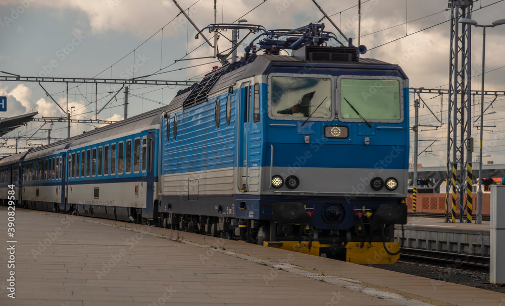 Blue electric engine with fast train to Prague arriving from Pilsen main station