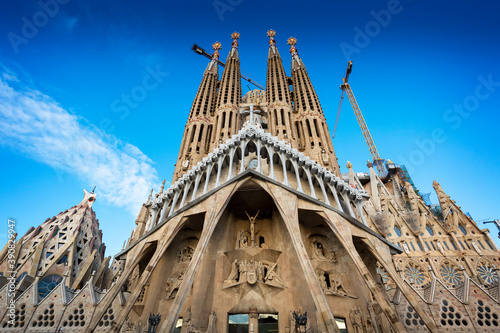 Sagrada Familia church (Gaudi) in Barcelona with blue sky and construction cranes in background