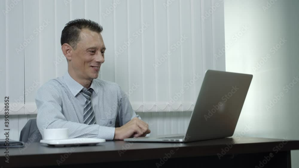A businessman, a corporate employee using a laptop to work in an office, is feeling overjoyed, as if hoping for something he had planned on the verge of success. A businessman, a corporate employee using a laptop to work in an office, is feeling overjoyed, as if hoping for something he had planned on the verge of success.