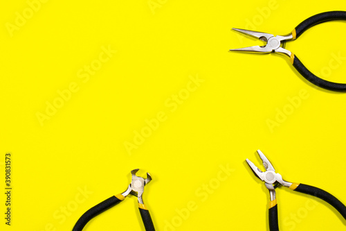 Tools on a yellow background with space for text. Pliers, biters, rounds, tongs A banner for a construction store photo
