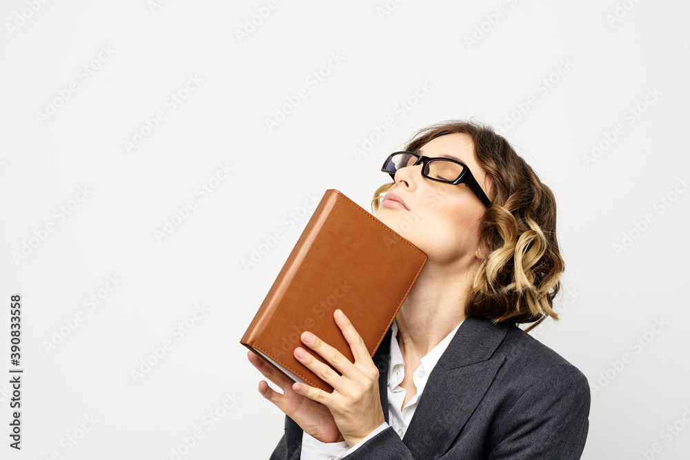 Business woman with notepad and glasses work light background cropped view of suit model. Business woman with notepad and glasses work light background cropped view of suit model.