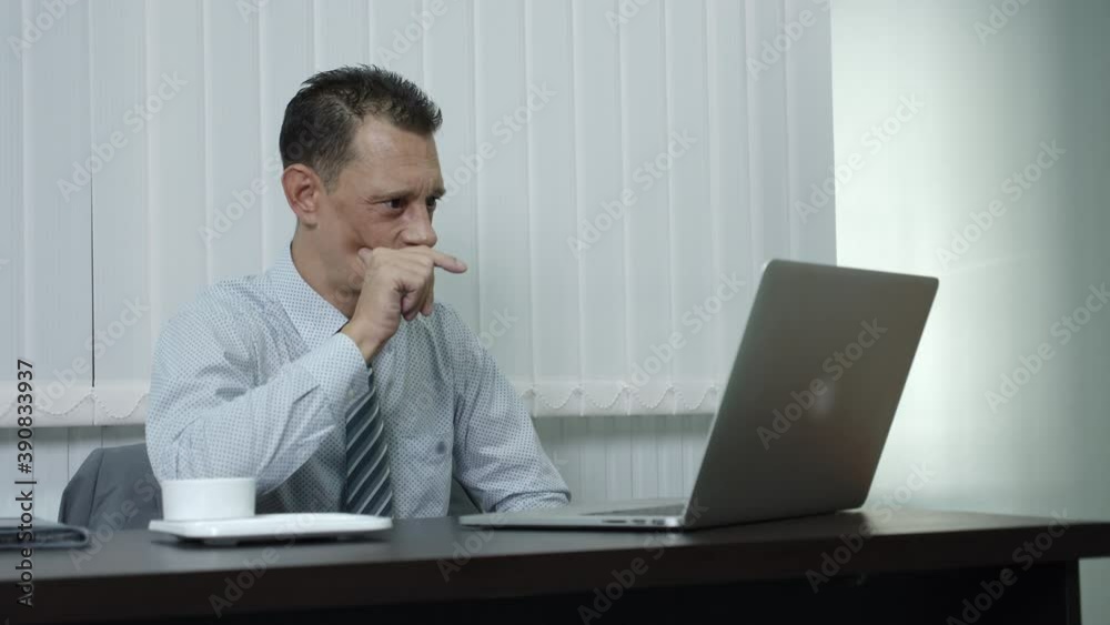 A businessman who is a company employee using a laptop to work in an office is seriously thinking about job. A businessman who is a company employee using a laptop to work in an office is seriously thinking about job.