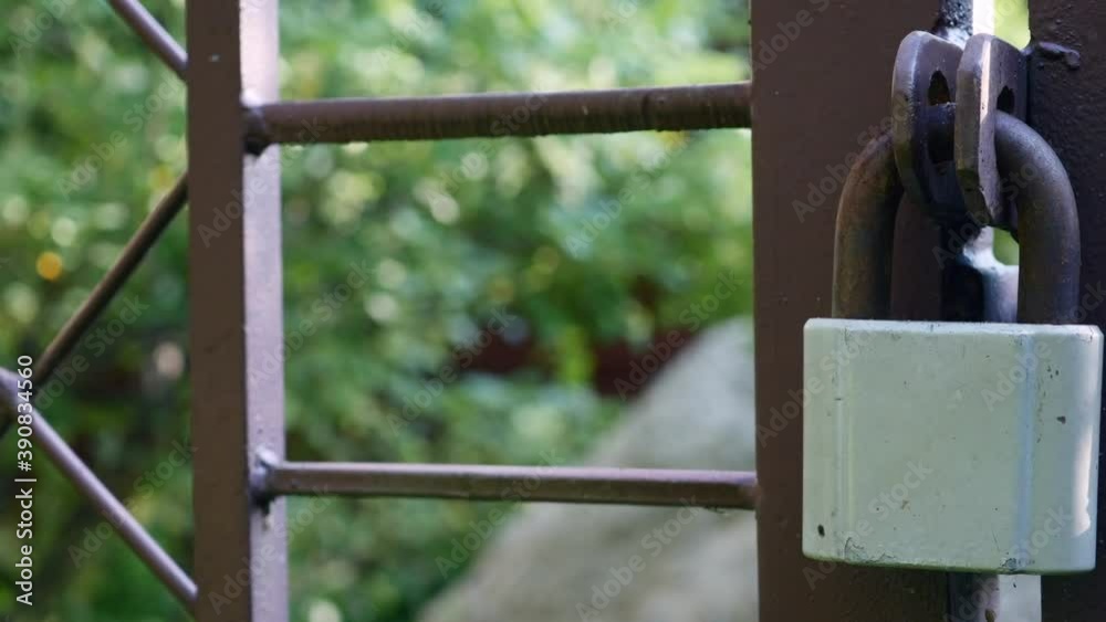 Iron Metallic Brown Fence With Gate And Stainless Steel Padlock On A Summer Day. Dolly Slider Shot.. Iron Metallic Brown Fence With Gate And Stainless Steel Padlock On A Summer Day. Dolly Slider Shot..