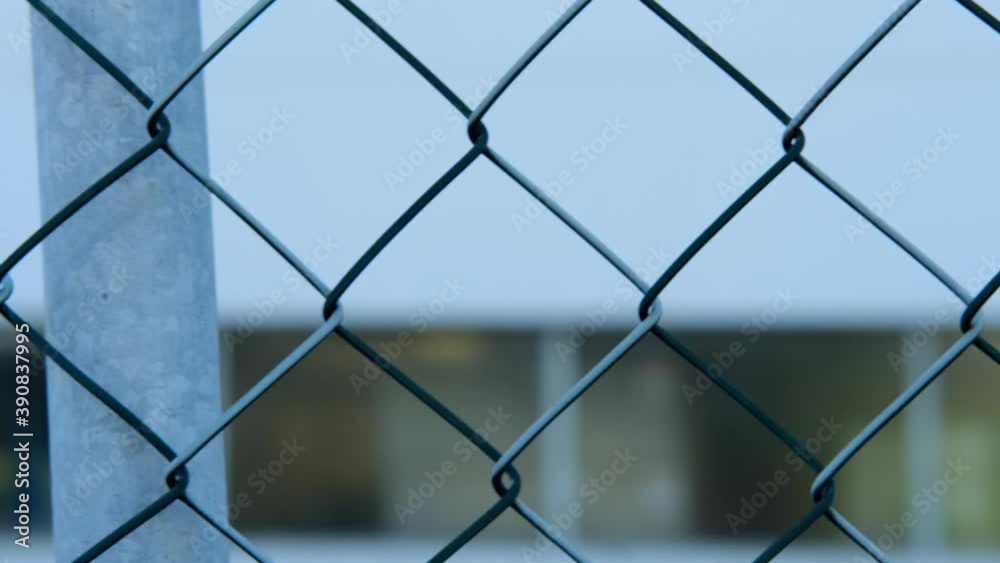 blue office building fenced with a high barbed wire fence on top, petitionary office, guarded area, concept prison, security zone blue office building fenced with a high barbed wire fence on top, petitionary office, guarded area, concept prison, security zone