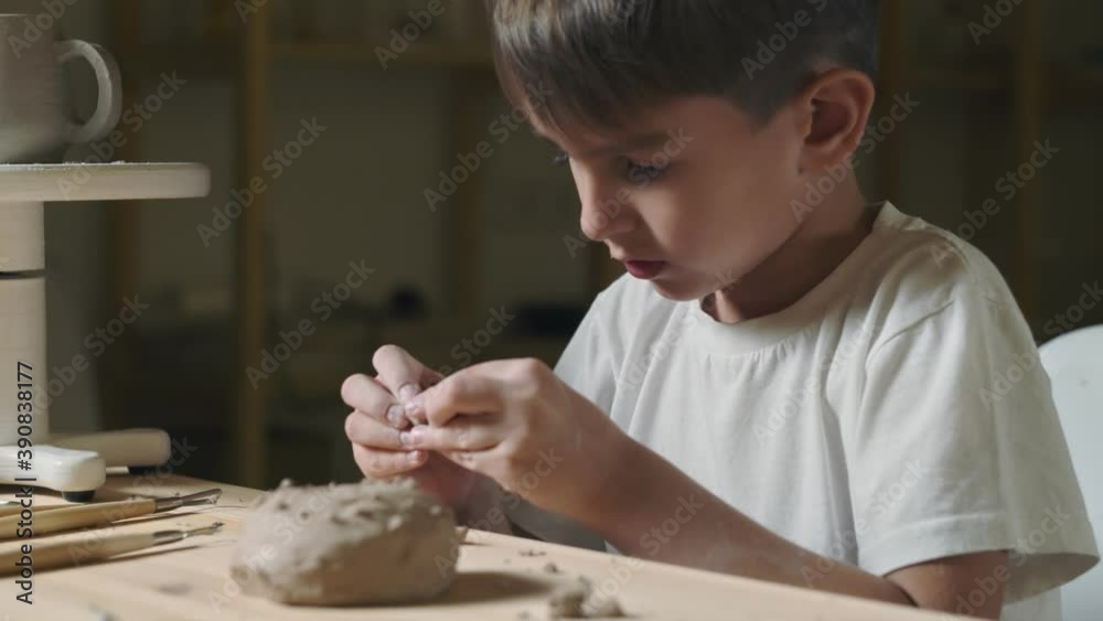 Close up of little boy plays with clay in pottery class Close up of little boy plays with clay in pottery class
