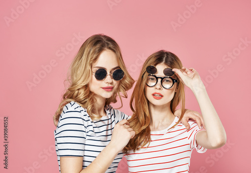 Women in striped t-shirts wearing sunglasses fashion studio pink background