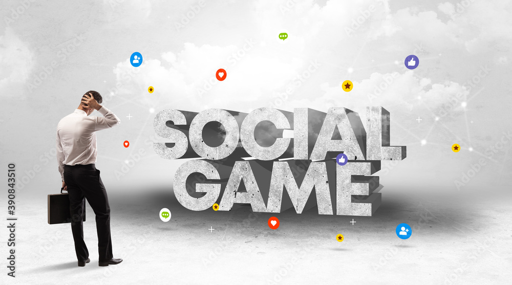 Young businessman standing in front of SOCIAL GAME inscription, social media concept Young businessman standing in front of SOCIAL GAME inscription, social media concept