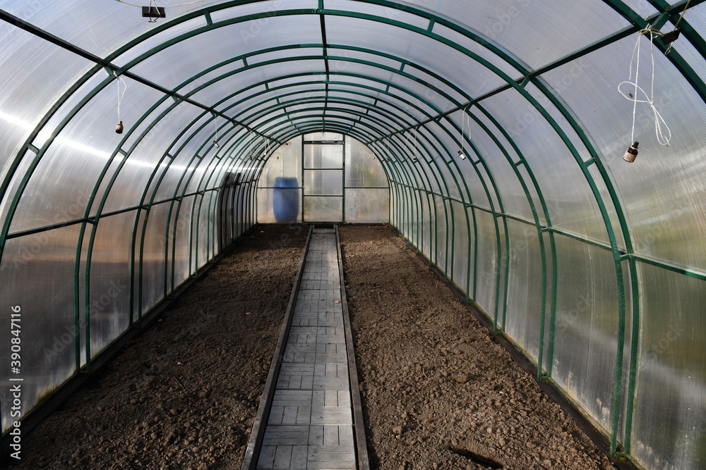 Freshly dig up empty beds in a greenhouse of polycarbonate. The track is lined with tiles. Neat beds. Freshly dig up empty beds in a greenhouse of polycarbonate. The track is lined with tiles. Neat beds.