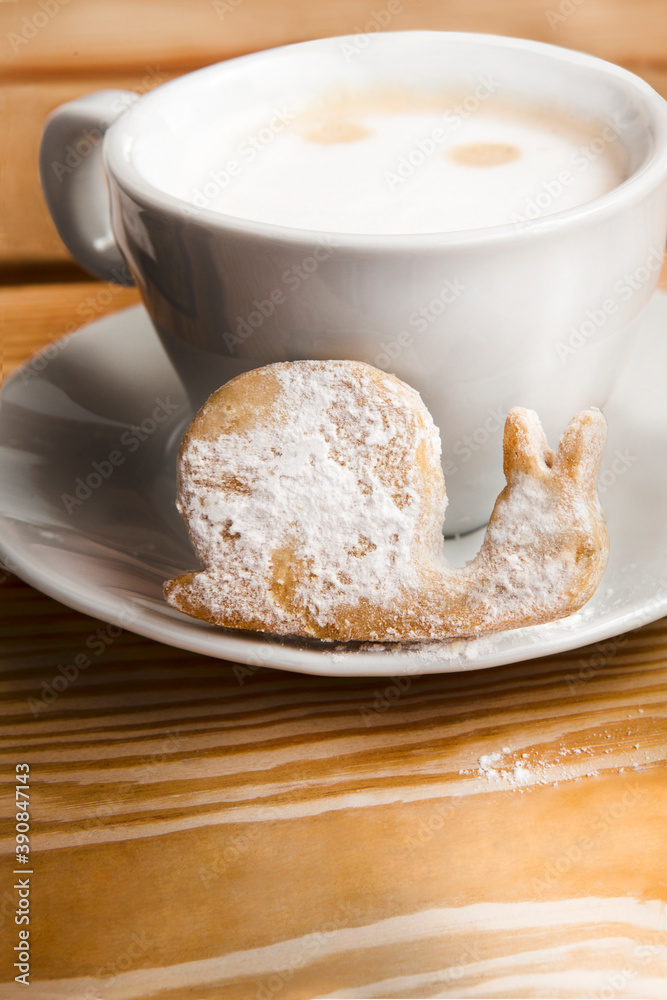 coffee drink in a white mug on a plate with a cake in the form of a snail, сlose, on a wooden surface, vertical image, nobody coffee drink in a white mug on a plate with a cake in the form of a snail, сlose, on a wooden surface, vertical image, nobody
