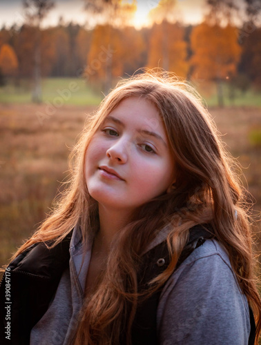 teenage girl with long blonde hair in autumn forest 