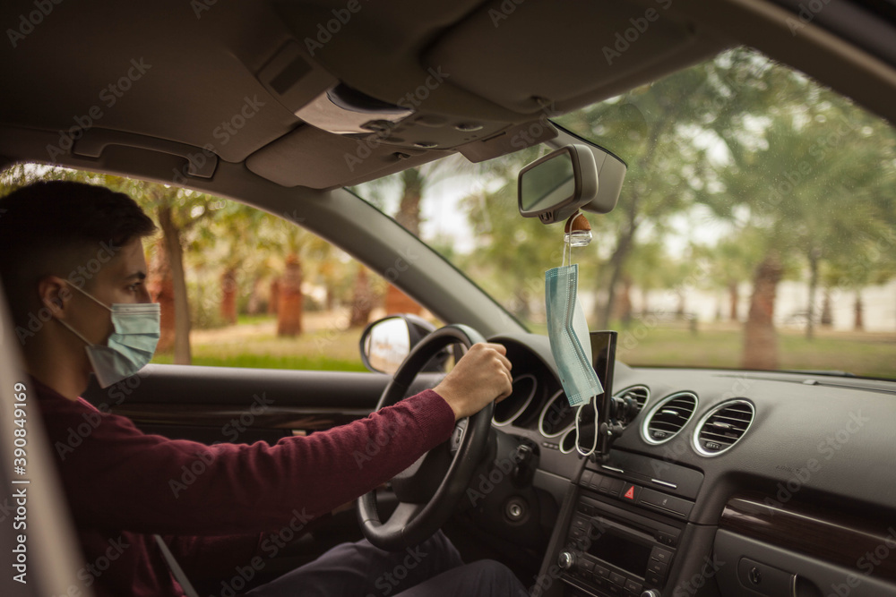 man with mask inside car looking at mobile phone driving man with mask inside car looking at mobile phone driving