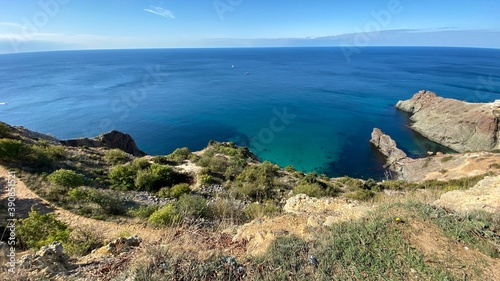 Panoramic seascape - calm azure sea  horizon  rocks and mountains surround the Black Sea bay in Crimea  Cape Fiolent in Sevastopol.