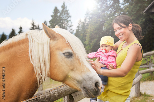 Mom with her daughter having fun at farm ranch and meeting a horse - Pet therapy concept in countryside with horse in the educational farm - Horse therapy concept with children