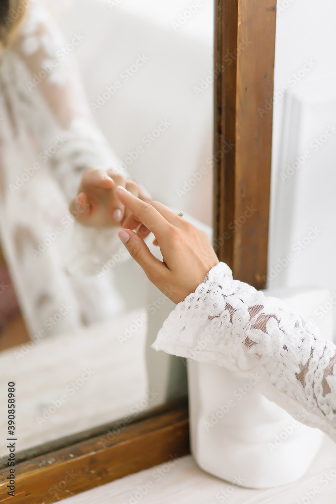 Obraz premium woman touches a mirror in which a reflection