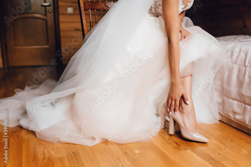 Bride in a white wedding dress puts tuli on her legs © Hanna Chayka