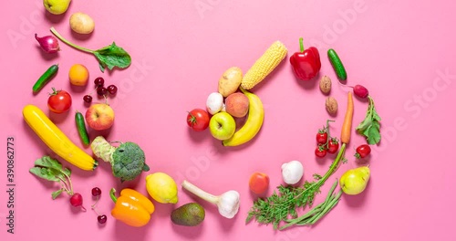 Fresh organic vegetables and fruits move into a pile on a pink background, stop motion. Vegetables animation. 
Flat lay 4 video with vegetables.