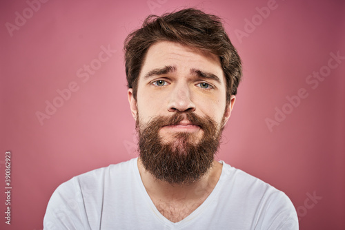 bearded man in white t-shirt emotions displeased facial expression studio pink background © SHOTPRIME STUDIO