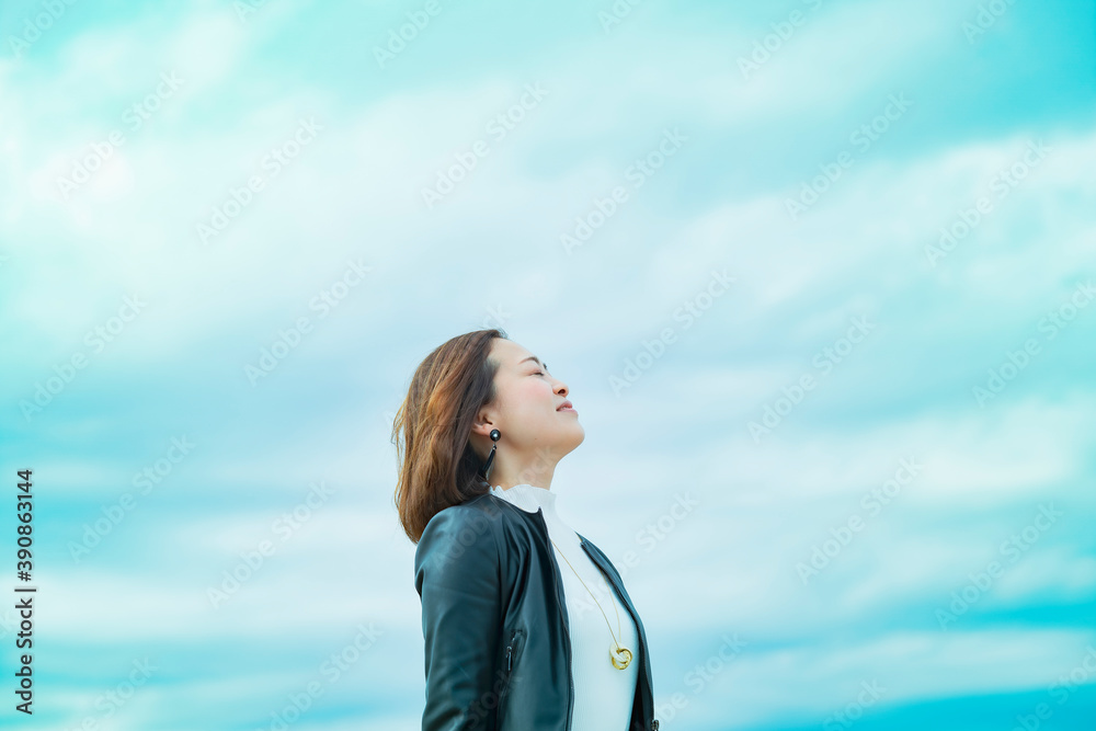 空を見上げるカジュアルな服装のビジネスウーマン