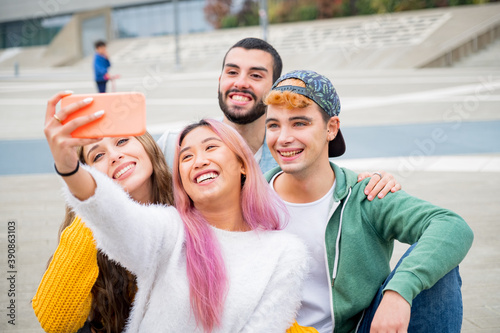 Group of young friends taking a selfie in the city - Happy millennials sharing content on social media - People, technology and lifestyle photo