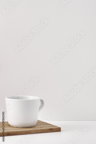 The mug stands on a stack of books on a white background. Natural and eco-friendly materials. Copy space, mock up