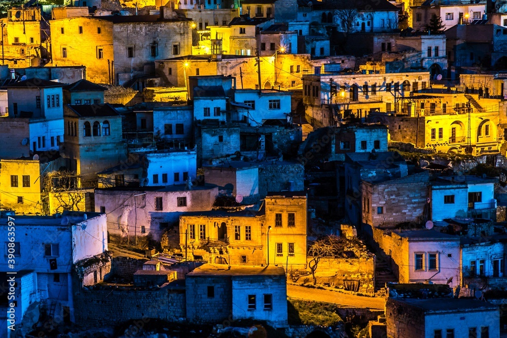 Great shot of stone-house ruins and narrow streets of Ortahisar, Cappadocia, partly illiminated with street lamps at night. .