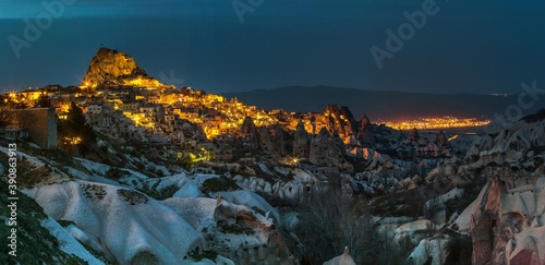 Fototapeta Naklejka Na Ścianę i Meble -  Amazing Uchhisar Castle (a large rock formation full of holes, rooms and corridors) and the city at night. It attracts visitors with its intriguing history. Cappadocia, Turkey.