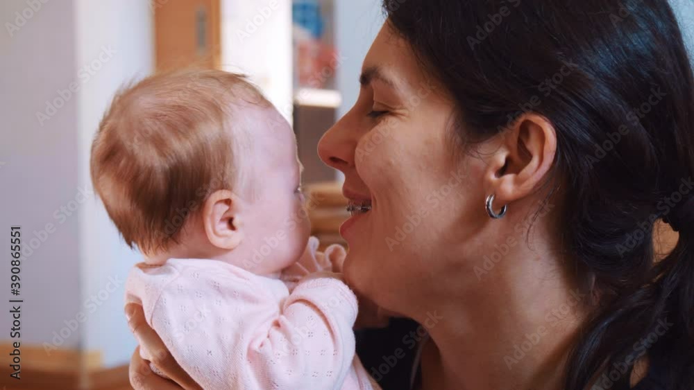 A mother who kisses and enjoys a small baby. A mother who kisses and enjoys a small baby.