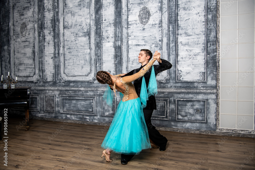 young couple in evening dance costumes dancing tango in the ballroom young couple in evening dance costumes dancing tango in the ballroom