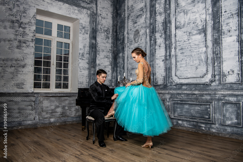 a young man sits at the piano and looks at a dancing partner standing next to him a young man sits at the piano and looks at a dancing partner standing next to him